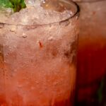 Three colorful summer cocktails with mint, lime, and fruit garnishes on a marble surface — neon bar vibe